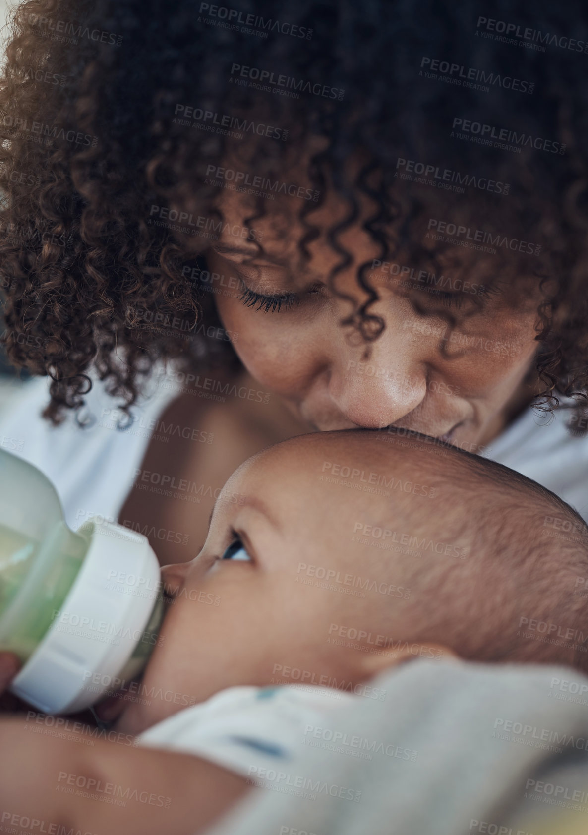 Buy stock photo Shot of an adorable baby girl being bottle fed by her mother on the sofa at home