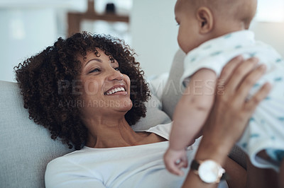 Buy stock photo Shot of a young woman relaxing with her adorable baby girl on the sofa at home