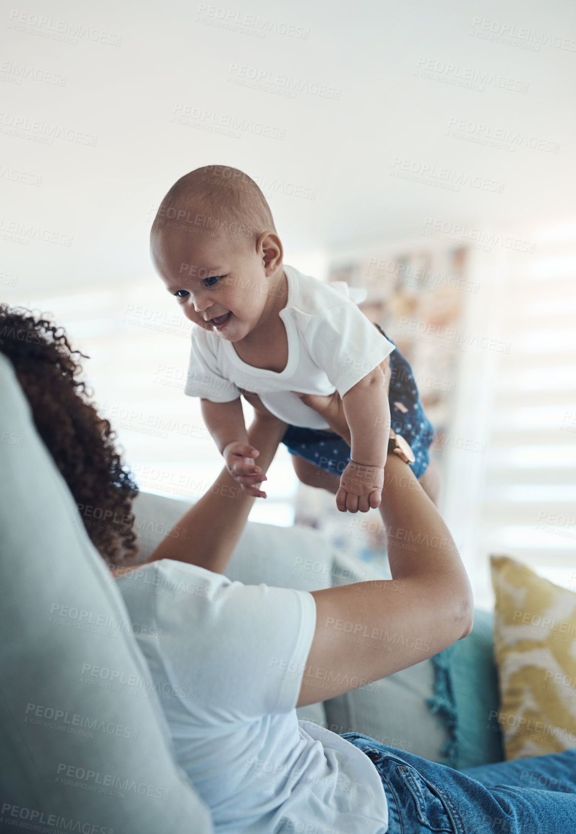Buy stock photo Shot of a young woman relaxing with her adorable baby girl on the sofa at home