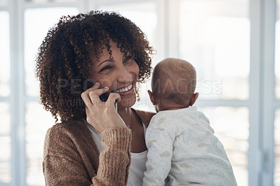 Buy stock photo Shot of a young woman using a smartphone while carrying her adorable baby girl at home