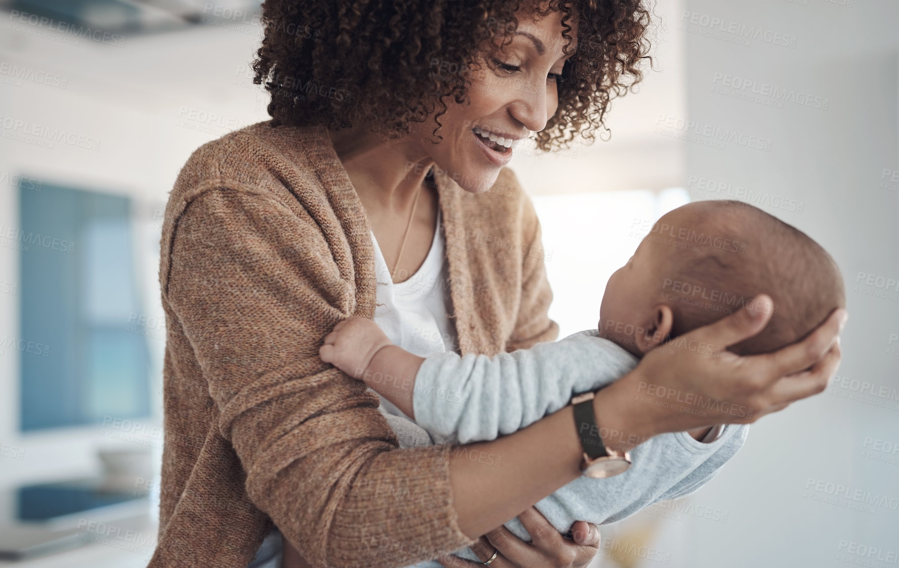 Buy stock photo Shot of a young woman carrying her adorable baby girl at home