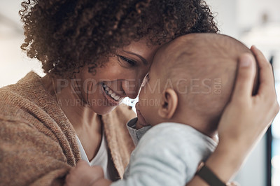 Buy stock photo Shot of a young woman carrying her adorable baby girl at home