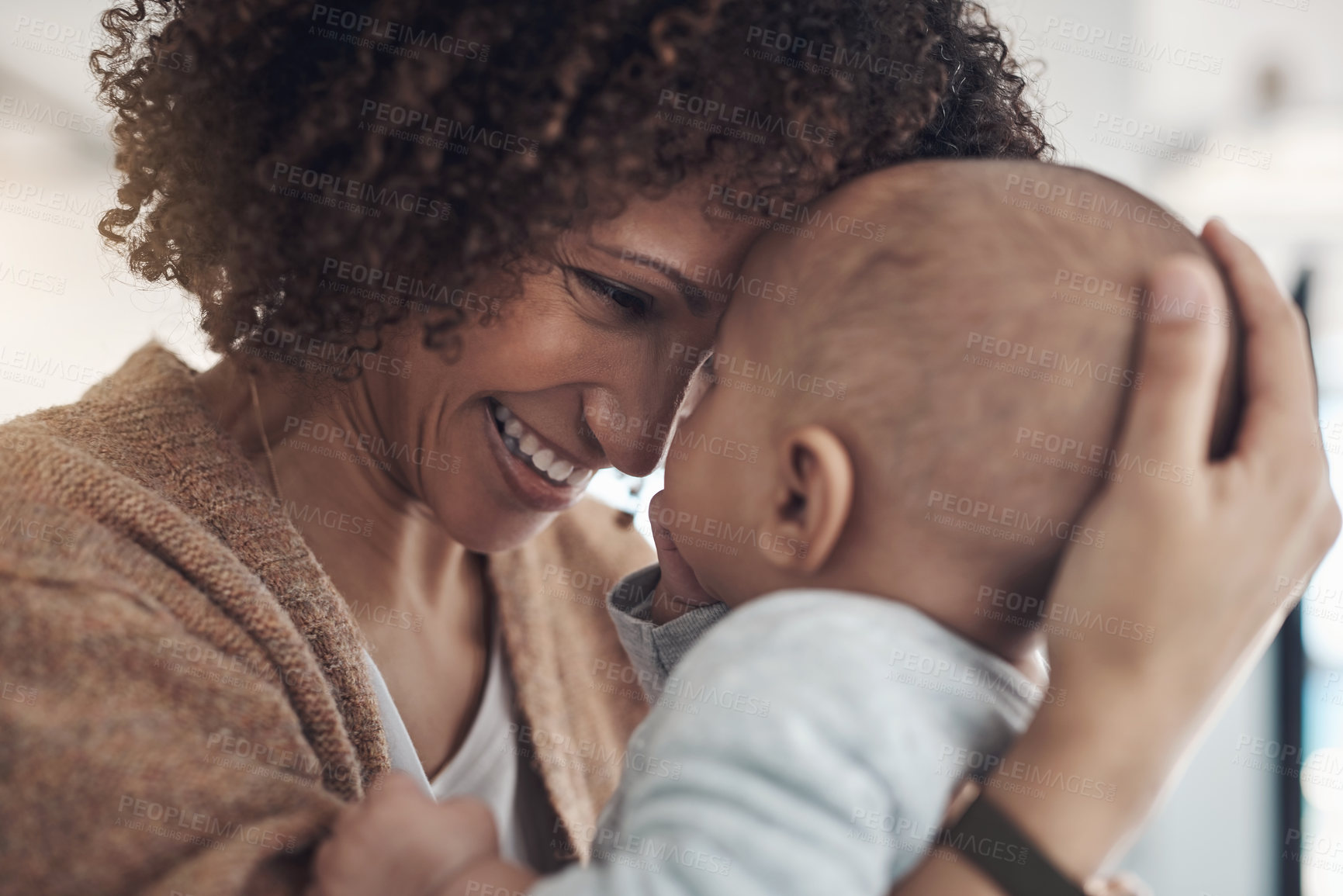 Buy stock photo Shot of a young woman carrying her adorable baby girl at home