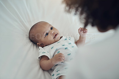 Buy stock photo Shot of an adorable baby girl gazing at her mother on the bed at home