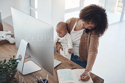 Buy stock photo Shot of a young woman using a smartphone and computer while caring for her adorable baby girl at home