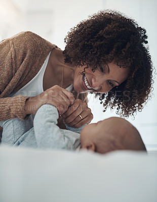 Buy stock photo Shot of a young woman playing with her adorable baby girl on the bed at home