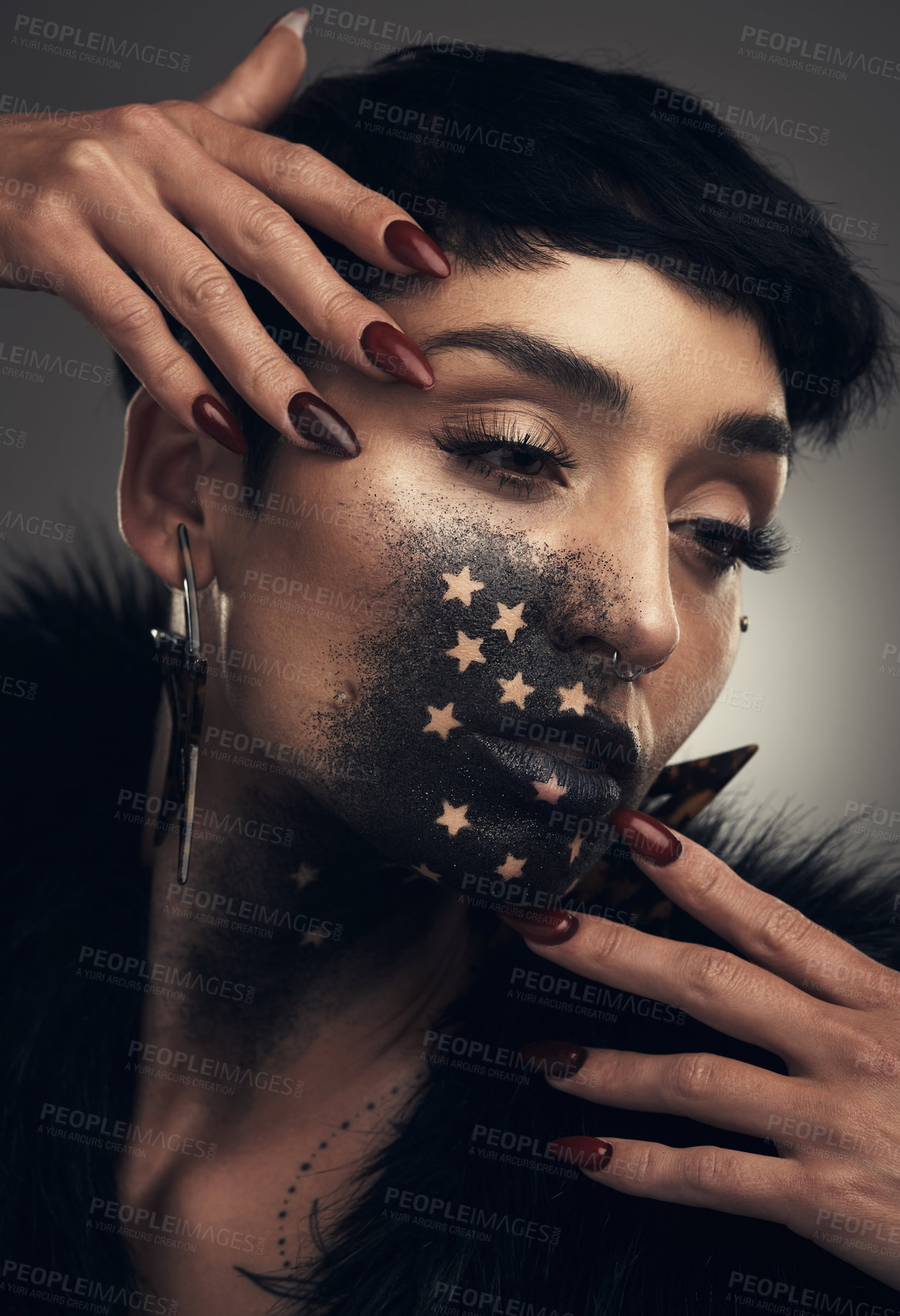 Buy stock photo Studio shot of a young woman posing with paint on her face on a grey background