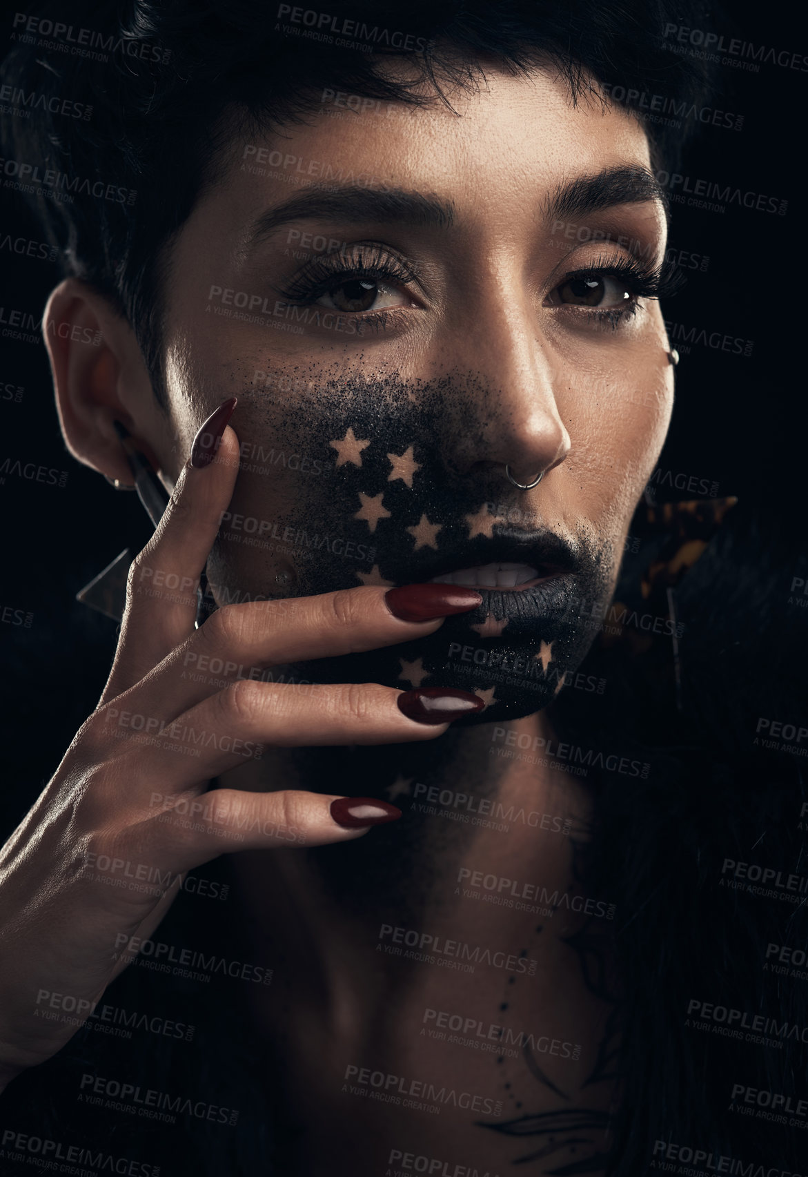 Buy stock photo Studio shot of a young woman posing with paint on her face on a grey background