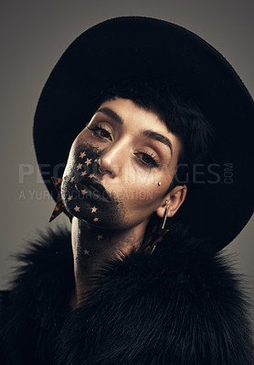 Buy stock photo Studio shot of a young woman posing with paint on her face on a grey background