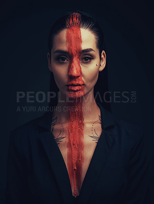 Buy stock photo Studio shot of a young woman posing with paint on her face on a black background