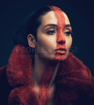 Buy stock photo Studio shot of a young woman posing with paint on her face on a black background