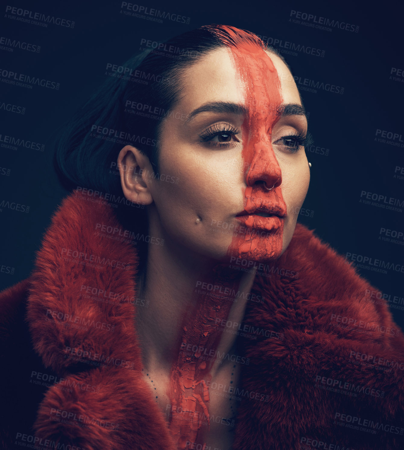 Buy stock photo Studio shot of a young woman posing with paint on her face on a black background