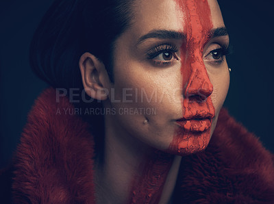 Buy stock photo Studio shot of a young woman posing with paint on her face on a black background