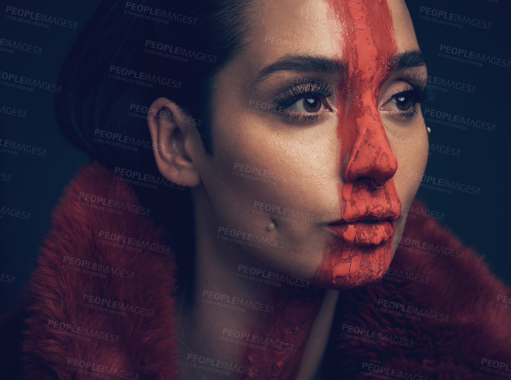 Buy stock photo Studio shot of a young woman posing with paint on her face on a black background