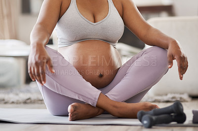 Buy stock photo Cropped shot of a pregnant woman doing yoga at home