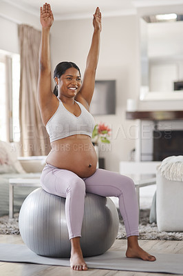 Buy stock photo Shot of a beautiful young pregnant woman exercising at home