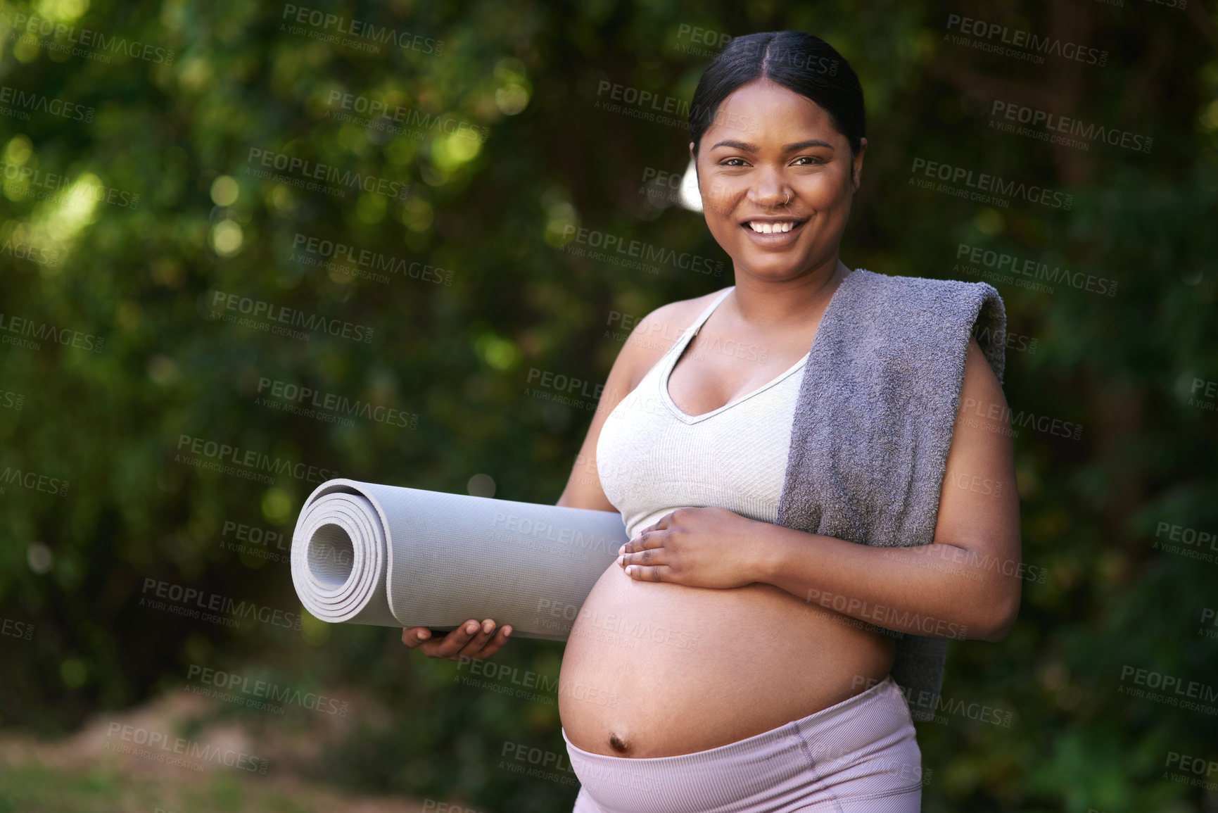 Buy stock photo Shot of a beautiful young pregnant woman standing outside with her yoga mat