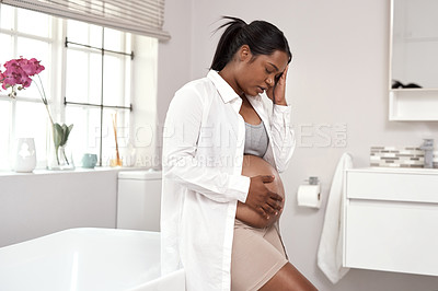 Buy stock photo Shot of a pregnant woman looking unwell at home