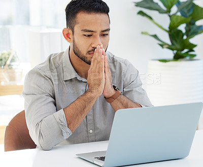 Buy stock photo Shot of a young man using his laptop at work in a modern office