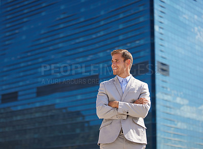 Buy stock photo Shot of a young businessman posing behind a building in the city