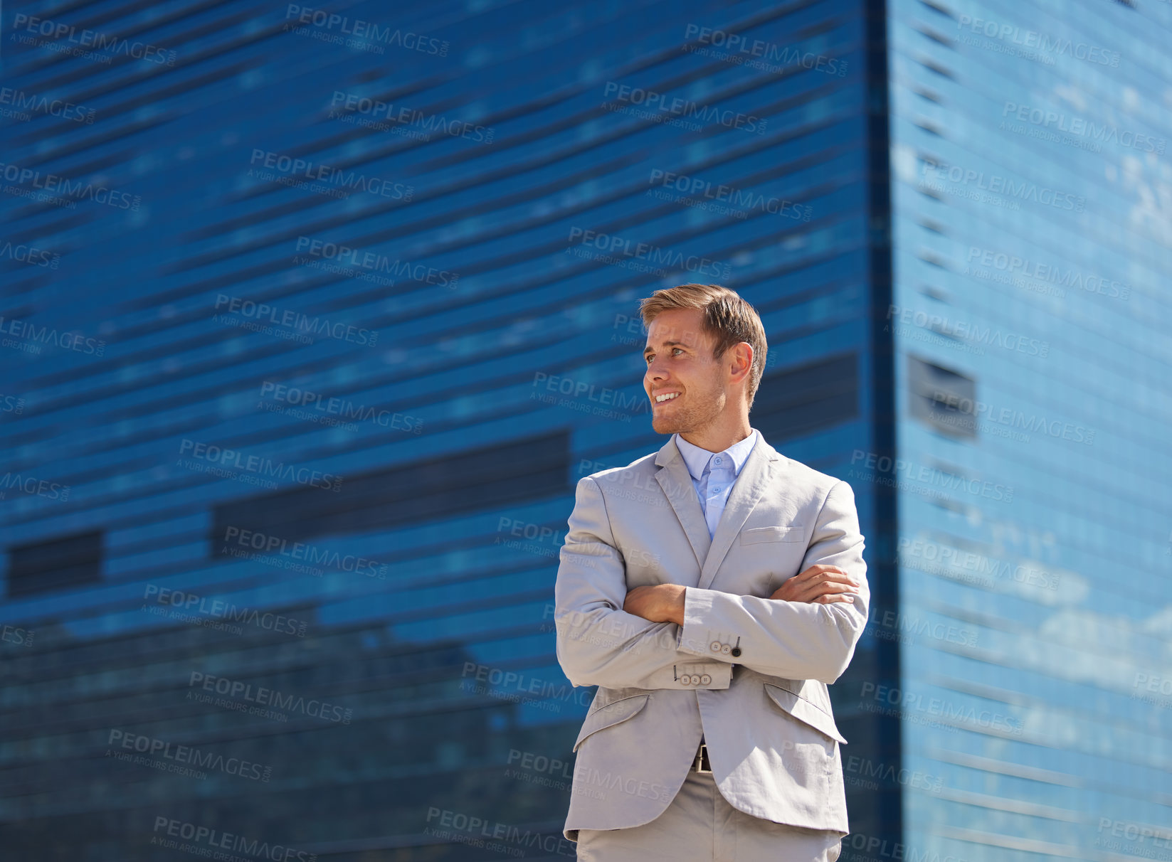 Buy stock photo Shot of a young businessman posing behind a building in the city