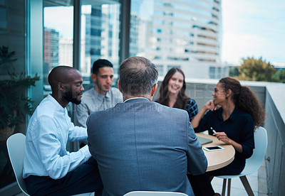 Buy stock photo Shot of a group of businesspeople having a meeting together on the balcony of an office