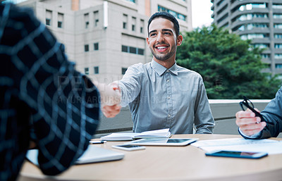 Buy stock photo Shot of a young businessman shaking hands with a colleague during a meeting on the balcony of an office