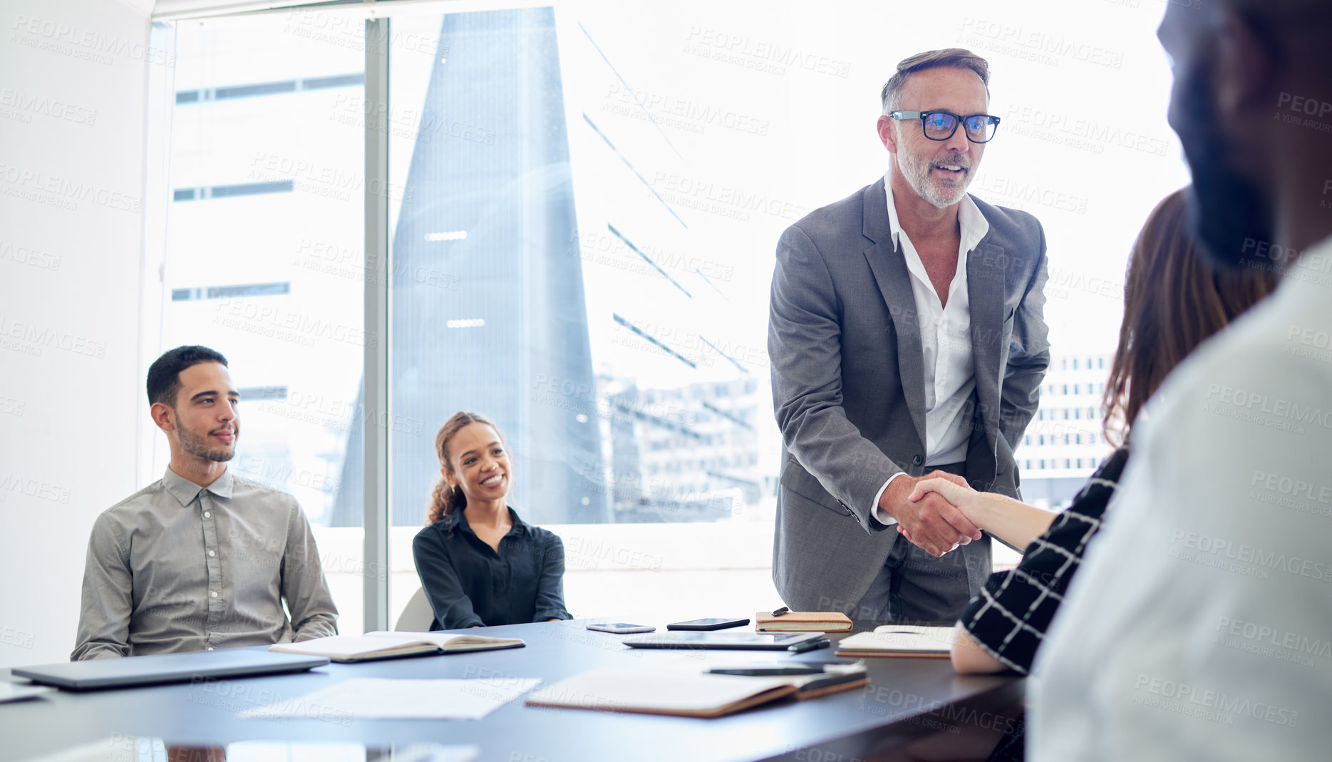Buy stock photo Businessman, meeting and handshake with team for partnership, deal or agreement in conference. Man, CEO or executive shaking hands with employee for hiring, recruiting or b2b together at workplace