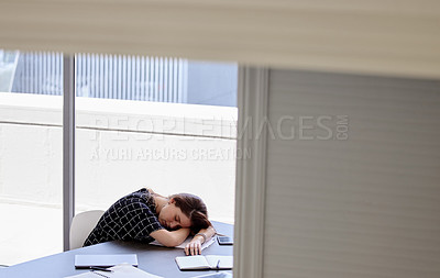 Buy stock photo Shot of a young businesswoman taking a nap in her office
