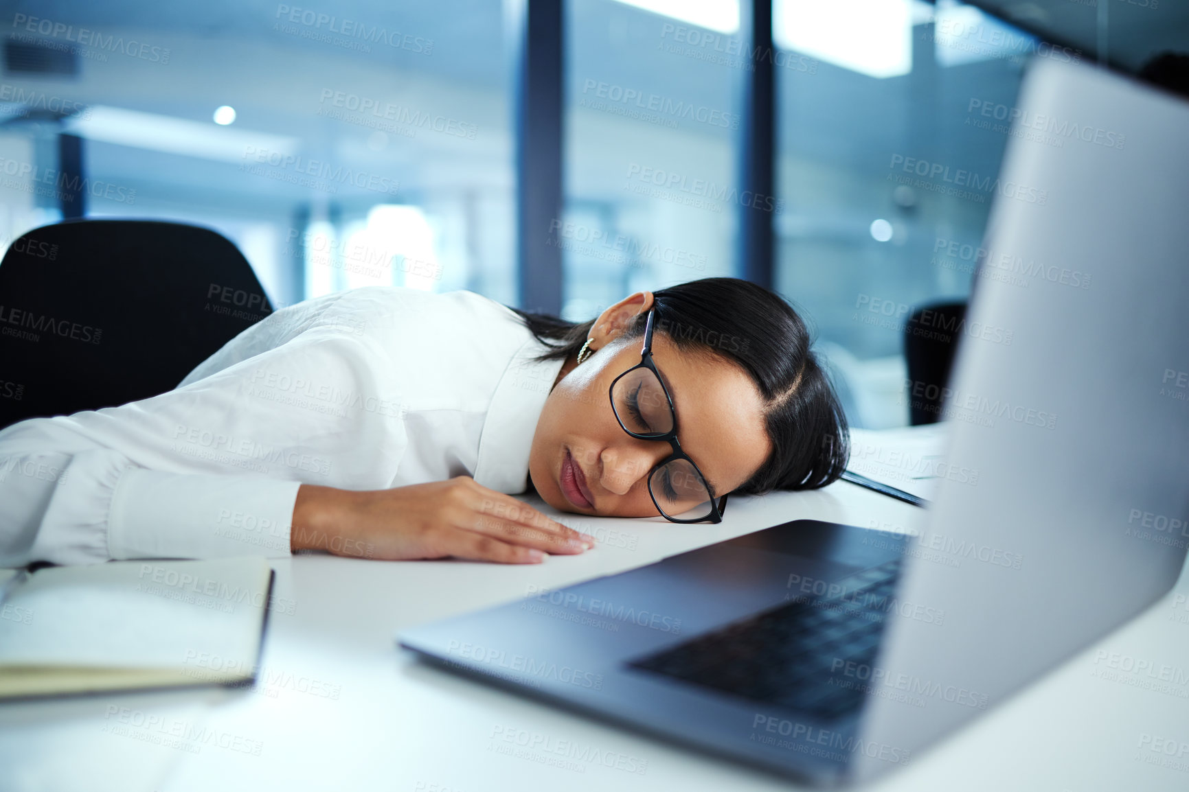 Buy stock photo Shot of a young businesswoman taking a nap at her desk