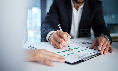 Buy stock photo Shot of two business colleagues filling out paperwork in the office