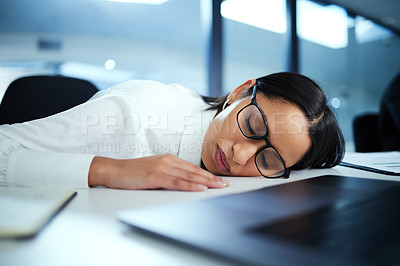 Buy stock photo Shot of a young businesswoman taking a nap at her desk
