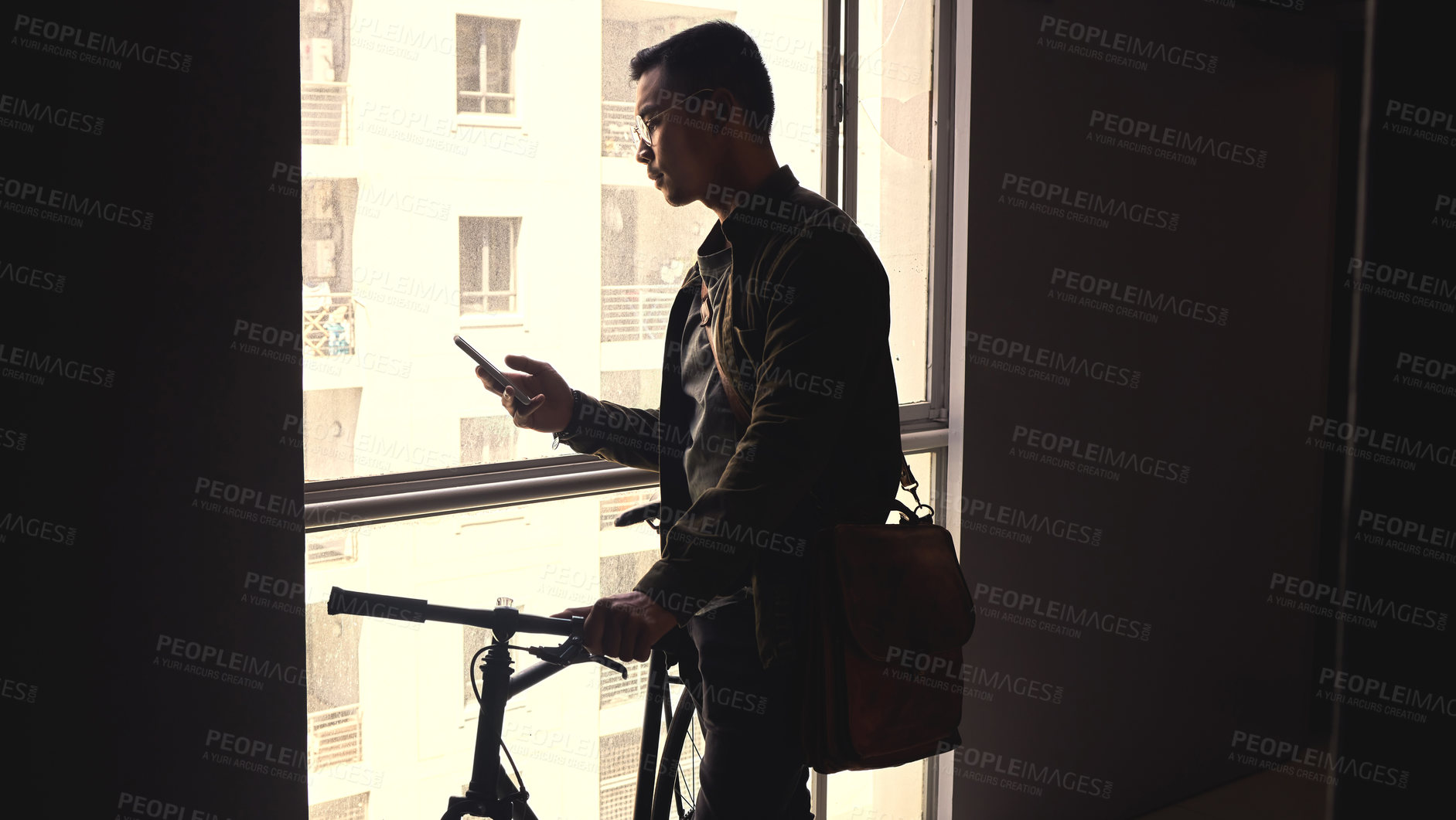Buy stock photo Student, bicycle and man with cellphone, typing and connection with internet, bag and mobile user. Apartment, cyclist and eco friendly travelling with smartphone, social media and shadow with window