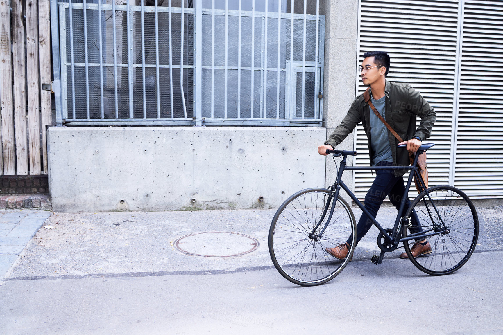 Buy stock photo Shot of a young man using a bicycle in the city