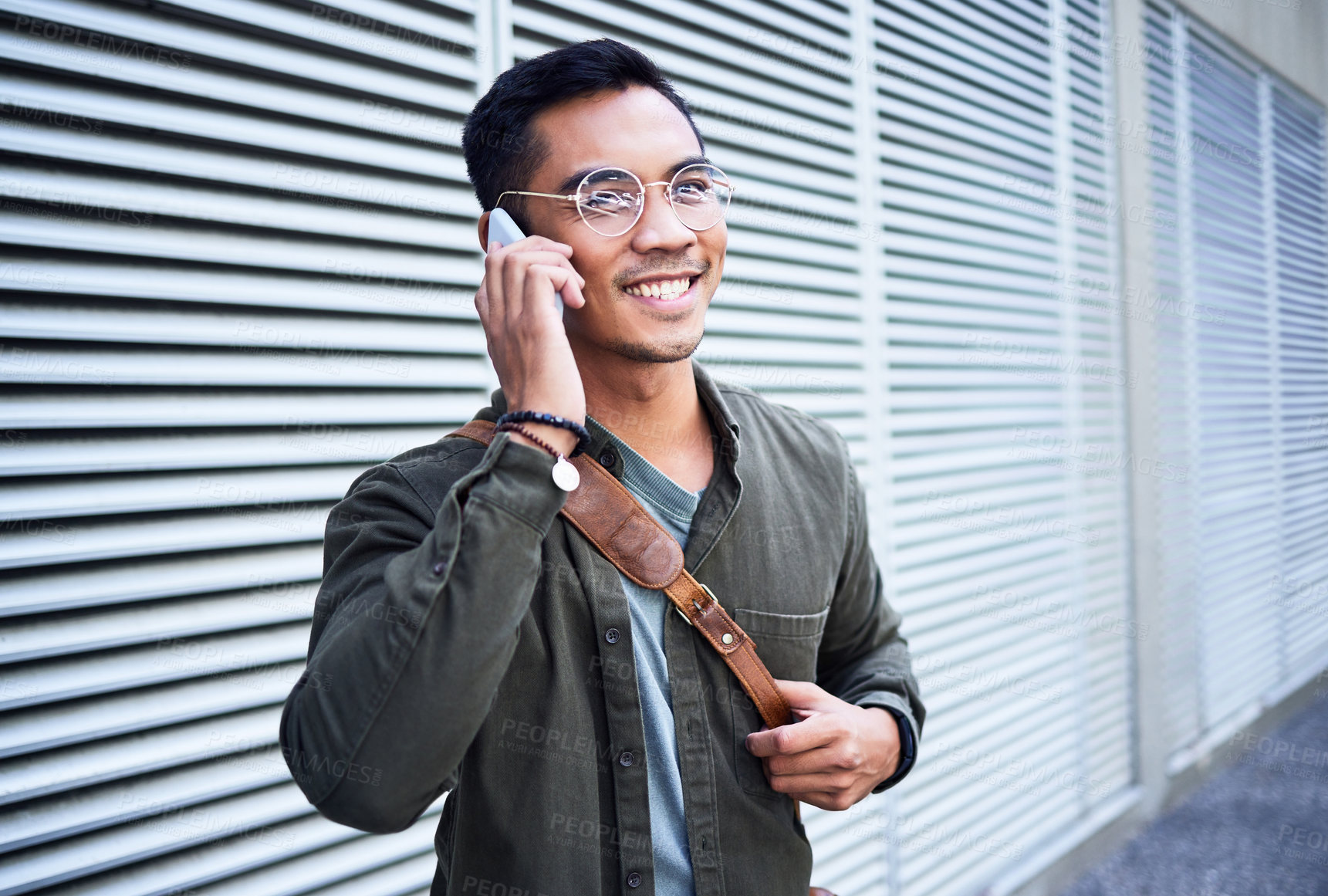 Buy stock photo Shot of a young man using a phone in the city