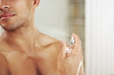 Buy stock photo Cropped shot of a spraying himself with perfume at home