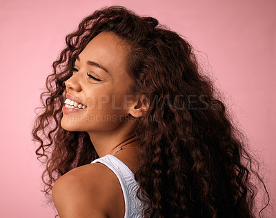 Buy stock photo Beauty, hair care and young woman in a studio with a natural, long and curly hairstyle. Happy, smile and profile of a brunette female model with a keratin salon treatment isolated by pink background.