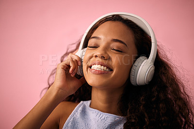 Buy stock photo Happy girl, relax and listening to music with headphones for jazz or beats on a pink studio background. Female person enjoying podcast, audio streaming or sound with smile for radio, song or playlist