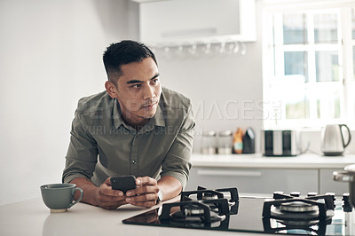 Buy stock photo Thinking, kitchen and man online with smartphone for trending updates or popular topics on social media or internet. Person, cellphone and texting for messaging or connection, streaming and download.