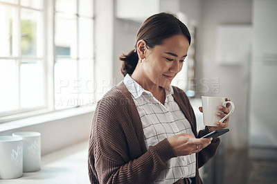 Buy stock photo Thinking, asian woman or coffee to relax, phone or browse on social media, website or app in home. Girl, smile or smartphone to drink, update or post of meme to connect at weekend of leisure