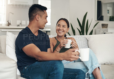 Buy stock photo Shot of a young couple drinking coffee while relaxing together at home