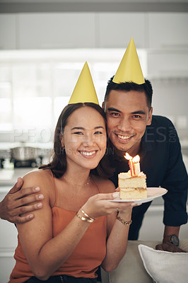 Buy stock photo Portrait, birthday cake and smile with a couple in their home, holding dessert for celebration in party hats. Love, candle or romance with a young man and woman celebrating together in their house