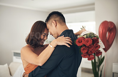 Buy stock photo Love, flowers and valentines day with a couple hugging in their home, in celebration of romance. Dating, rose boquet or surprise with a man and woman in a house to hug while bonding in intimacy