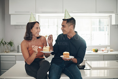 Buy stock photo Birthday cake, celebration and couple in a kitchen, happy and relax while bonding in their home, smile and laugh. Party, people and man with woman on counter for eating, fun and celebrating in Japan