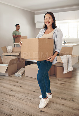 Buy stock photo Shot of a woman holding a box while moving into her new home with her partner