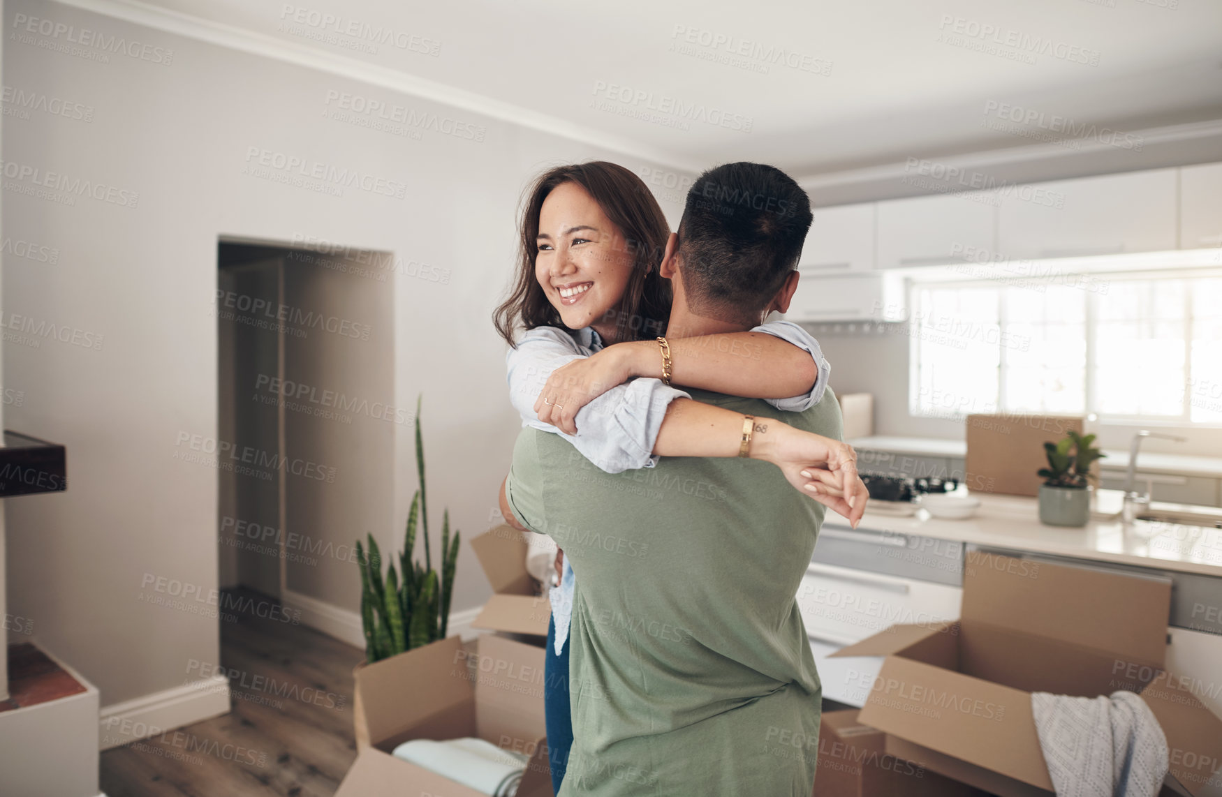 Buy stock photo Property, happy couple moving into their new home and boxes in living room. Happiness or smiling, mortgage or homeowners and people hugging celebrating with their new house or apartment together