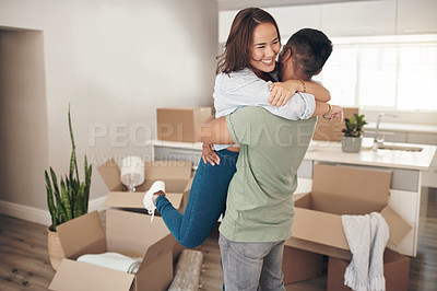 Buy stock photo Shot of a couple looking cheerful while moving into their new home