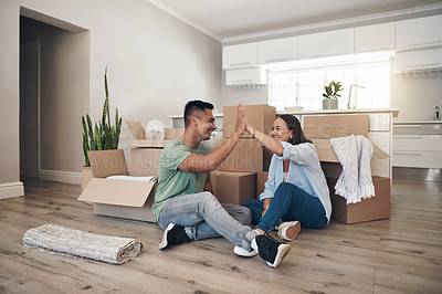 Buy stock photo Shot of a couple sharing a high-five while moving into their new home