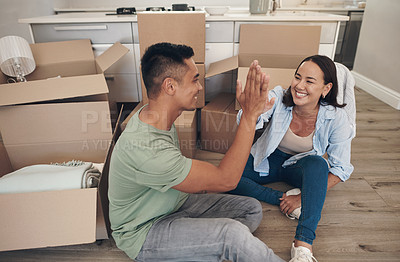 Buy stock photo Shot of a couple sharing a high-five while moving into their new home