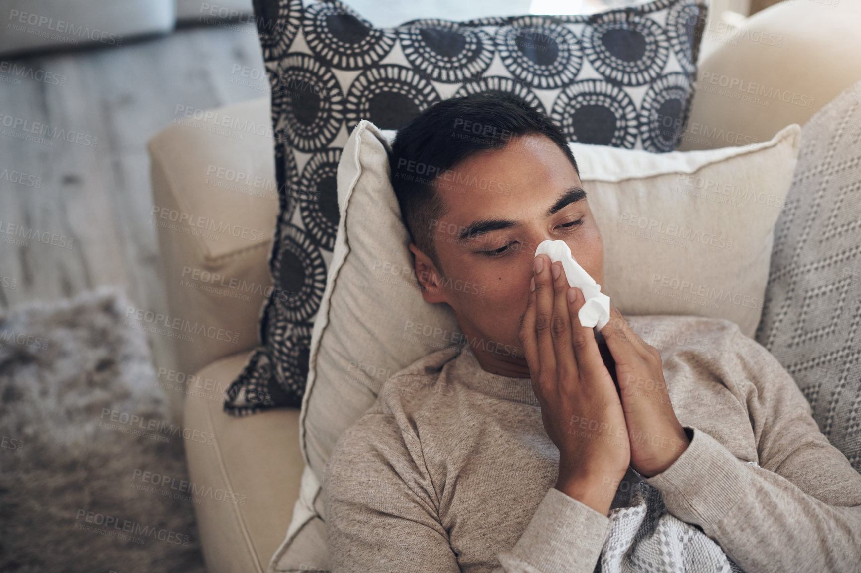 Buy stock photo Sick, man and blowing nose with tissue for sinus, flu or illness on living room sofa above at home. Top view of tired male person with paper for sneeze, fever or influenza and infection on couch